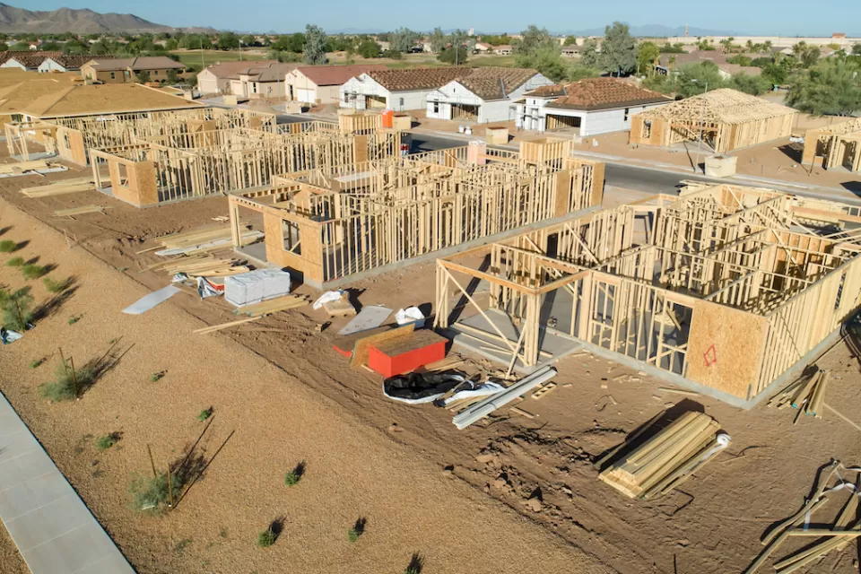 Aerial view of multiple wood-framed buildings under construction.